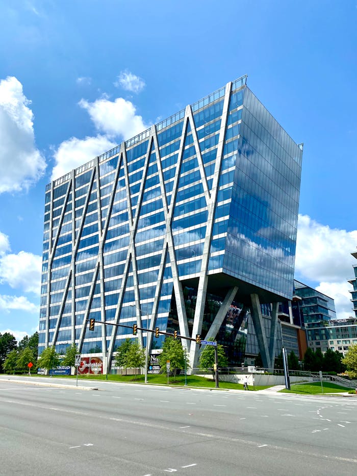 Services A striking modern office building with a geometric glass facade in an urban setting.