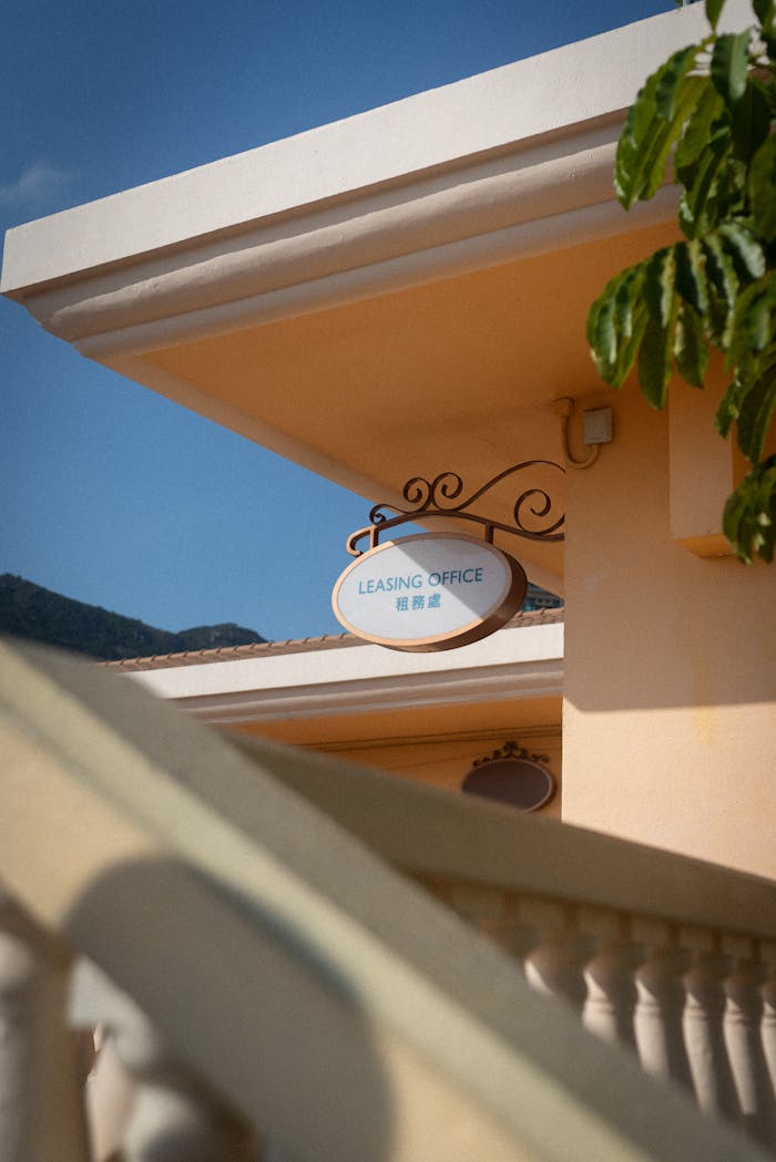 Services An elegant leasing office sign displayed amidst architectural elements against a clear blue sky.